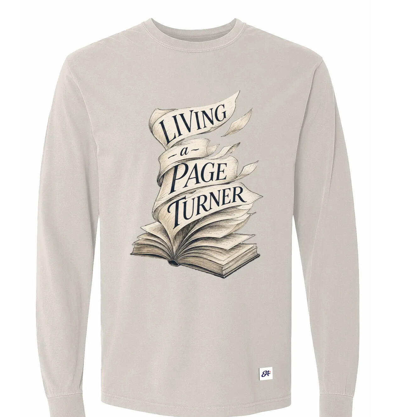 Ivory Living a Page Turner long-sleeve shirt with an open-book illustration and flowing page ribbons.